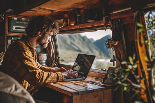 a man handsome using laptop in the camper car in the holiday