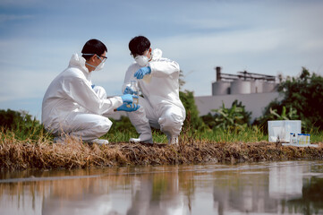 Factory scientists or biologists wear protective clothing while checking natural water sources,...
