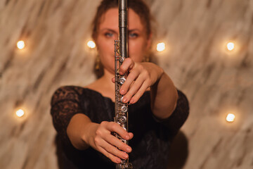 Musician with a flute, a woman of great talent, was shining brightly in the concert lights during her musical performance.