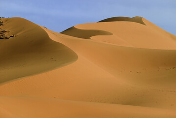 Fototapeta na wymiar SAND DUNES AND ROCK FORMATIONS IN THE REGION OF TADRART ROUGE IN THE SAHARA DESERT IN ALGERIA