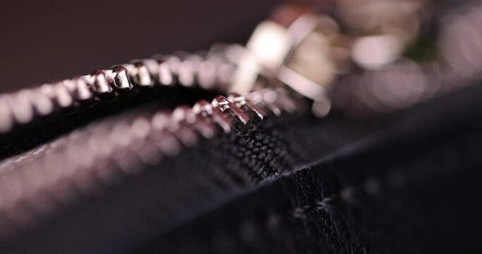 metal zipper on a black leather product, zipper on a black women's handbag close-up