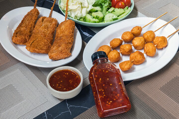 The fried meatballs made from a variety of meats and sausages, mixed with flour and seasonings with a delicious spicy sauce and come with cucumber, cabbage, tomato and lettuce as sides. Street Food.