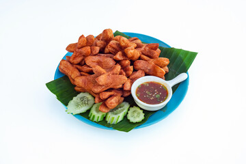 Delicious fried sausage mixed with flour and seasonings with delicious spicy sauce and cucumber on blue dish with white background. Asian Street Food. Deep fried sausage meatballs on blue plate.