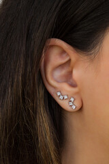Woman wearing beautiful stud earrings with zirconia.