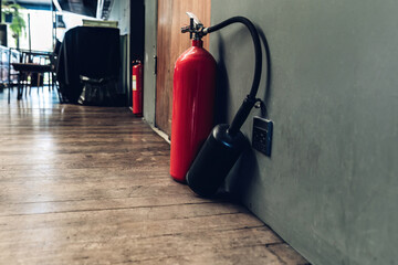 Fire extinguisher in the operating department . Install a fire extinguisher on the floor in building. Dry chemical powder fire extinguisher in corridor .a red fire-extinguisher hangs on floor - obrazy, fototapety, plakaty