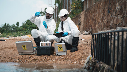 Scientist wear protection suit checking chemical and water analysis and water quality from factory. Protecting Against Hazards and Contamination.