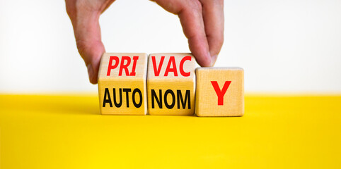 Privacy or autonomy symbol. Concept word Privacy or Autonomy on wooden cubes. Beautiful yellow table white background. Businessman hand. Business privacy or autonomy concept. Copy space.