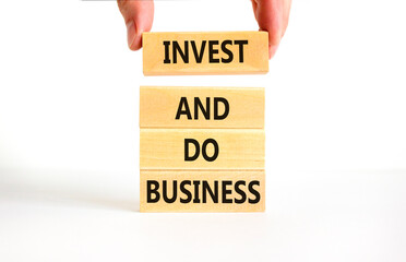 Invest and do business symbol. Concept word Invest and do business on beautiful wooden block....