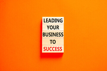 Leading your business to success symbol. Concept words Leading your business to success on wooden blocks. Beautiful orange table orange background. Leading your business to success concept. Copy space