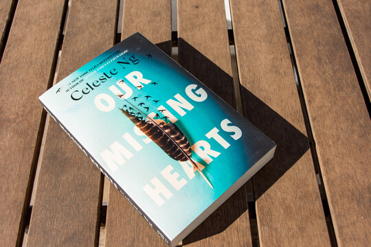 Close up Celeste Ng's Our Missing Hearts book on a wooden table.