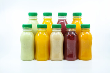 Obraz na płótnie Canvas Assorted Juices of orange, mango, pomegranate, avocado and Dates milkshake served in bottle isolated on background side view of healthy morning juice drink