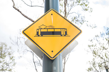 Yellow square information road sign with black tram