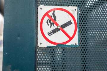 No smoking sign with symbols on the fence
