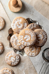 Homemade gingerbread cookies on parchment background with powdered sugar, text space, top view. Christmas traditional desserts concept