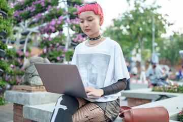 Gen z girl leather fashion with punk Asian woman working remotely on laptop digital nomad in...