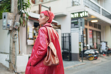 Gen z girl leather fashion with punk Asian woman tourist of local city Southeast Asia travel trendy pink hairstyle young female punk traveler walking around in town - Powered by Adobe