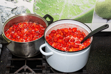 Juicy sweet strawberry jam is cooked in pans. Preparations for the winter