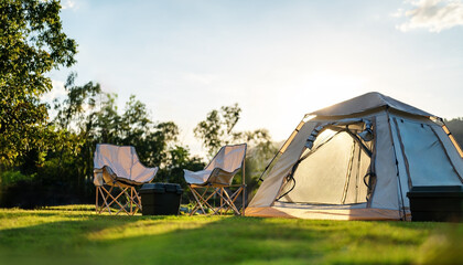nature, tent, camp, vacation, adventure, campground, grass, trip, campfire, camping. selective focused on lawn or green grass ground of camping ground, with camping tent in background and sunlight. © Garun Studios