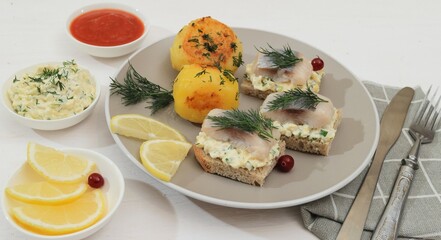 herring and potatoes, lemon in a saucer
