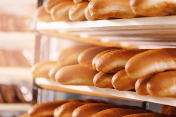 Poster Banner bakery, fresh bread with golden crust on store shelves, sunlight © Parilov
