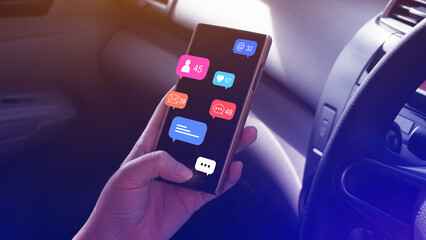 Obraz premium Woman using social media and digital online marketing concepts on mobile phones with icons such as notifications, messages, comments on the smartphone screen in a car.