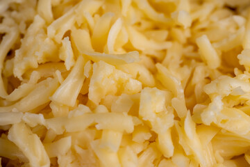 grated yellow semi-hard cheese with holes