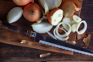 Ripe onion is a spicy product and vegetable. It is essential in the preparation of many delicious dishes. On an old background in a composition with kitchen accessories.