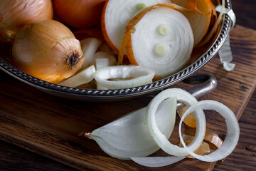 Ripe onion is a spicy product and vegetable. It is essential in the preparation of many delicious dishes. On an old background in a composition with kitchen accessories.