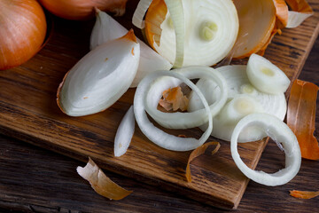 Ripe onion is a spicy product and vegetable. It is essential in the preparation of many delicious dishes. On an old background in a composition with kitchen accessories.