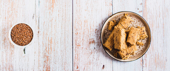 Pieces of halva with flax seeds on a plate on the table top view web banner