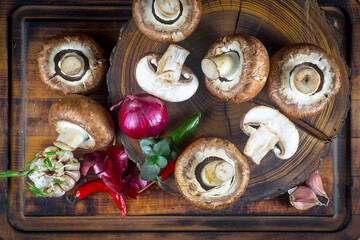 Champignon mushrooms in composition with food ingredients on old background