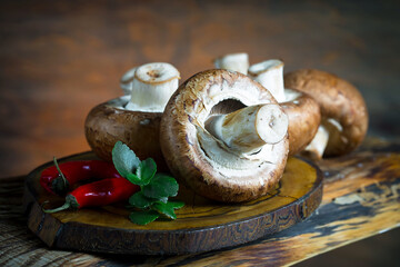 Champignon mushrooms in composition with food ingredients on old background