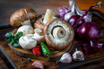 Champignon mushrooms, a fresh natural product, in a composition with kitchen ingredients, on an old background.