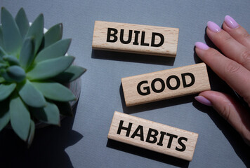 Build good habits symbol. Wooden blocks with words Build good habits. Beautiful grey background...