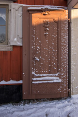 Open and snowy wooden gate a snowy sunny winter day in Stockholm