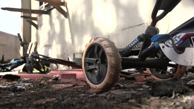 Camera is placed on the floor, showing some burnt bicycles and toys. an evidence to a brutal fight that took place in an Israeli community at Kibbutz Be'eri, southern Israel.