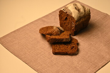 Sliced black bread on a grey background, loaf of black borodish fresh bread, healthy bread 	