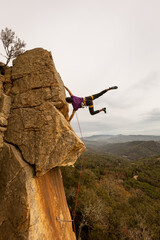 Person climbing in high mountains with yellow jacket rope and helmet in nature, confidence and risk, safety