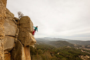 Person climbing in high mountains with yellow jacket rope and helmet in nature, confidence and...