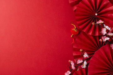 Marking Chinese New Year with a grand celebration. Top view photo of red paper fans, decorative...
