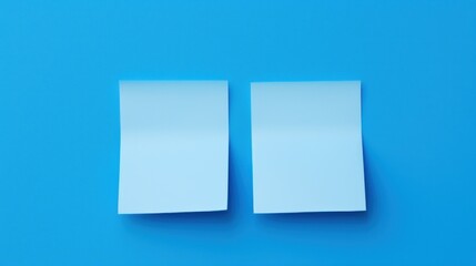 Fototapeta premium two pieces of white paper sitting on top of a blue surface with two smaller pieces of white paper next to each other.