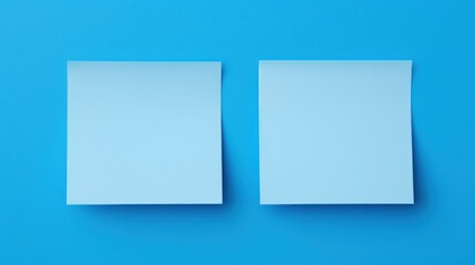  two pieces of paper sitting on top of each other on a blue surface with a shadow of one of the two rectangles on the left side of the paper.