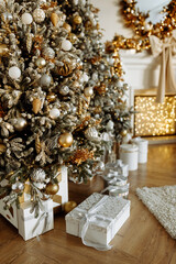 Christmas gifts under the Christmas tree at home. Beige and gold shades.