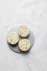 cut out raw black sesame scones dough on parchment paper, black sesame scones dough about to be baked, process of making scones