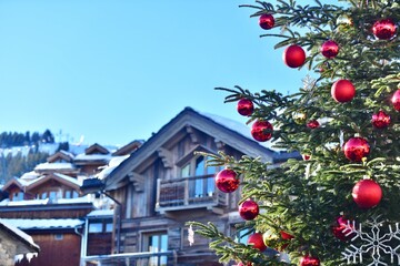 decorated christmas tree in front of chalet by winter 