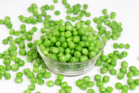 green peas matar in a glass bowl on white background.