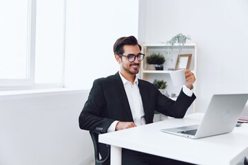 Fototapeta premium Man in office businessman sitting at desk and working in laptop, finance and startup concept, working lifestyle in bright office.