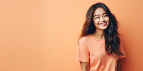 Obraz premium Beautiful young Asian woman dressed in Peach Fuzz pantone color casual style, posing in studio, copyspace