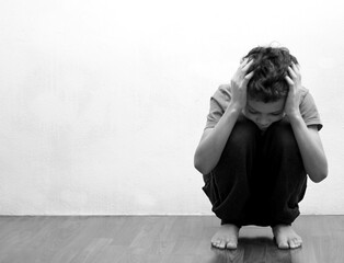 boy praying in poverty on the floor stock image with no help crying alone and all by himself on white background stock photo 