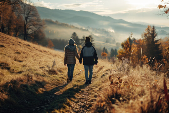 A picture capturing two people walking down a scenic path in the mountains. This image can be used to depict outdoor activities, adventure, and exploration
